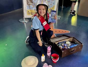 One of The Deep's Guides smiling with RNLI dress up props.