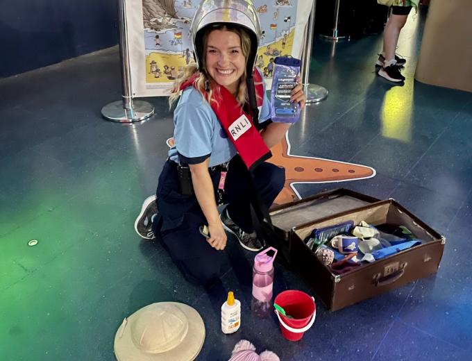 One of The Deep's Guides smiling with RNLI dress up props.