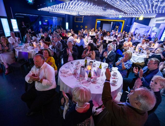 A large group of people sat around tables in Endless Ocean.