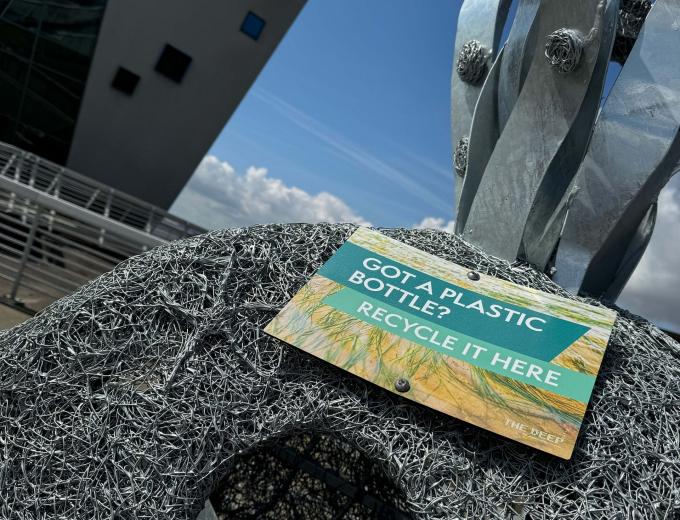 Got a plastic bottle? Recycle it here sign on the seagrass sculpture